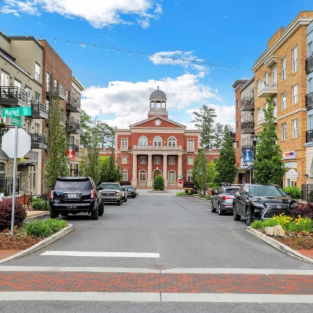 Street view of Alpharetta City Hall in downtown Alpharetta, Georgia, with brick buildings, parked cars, and a modern city center