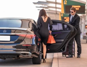 chauffeur receiving woman client from airport