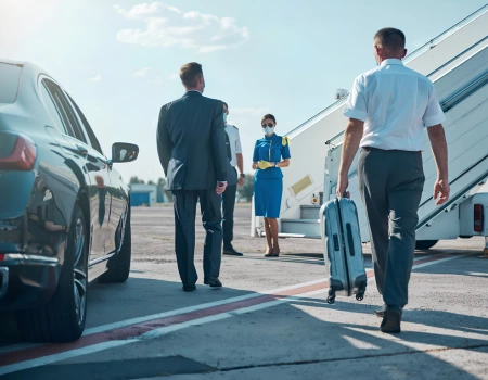 chauffeur assisting businessman with luggage at airport