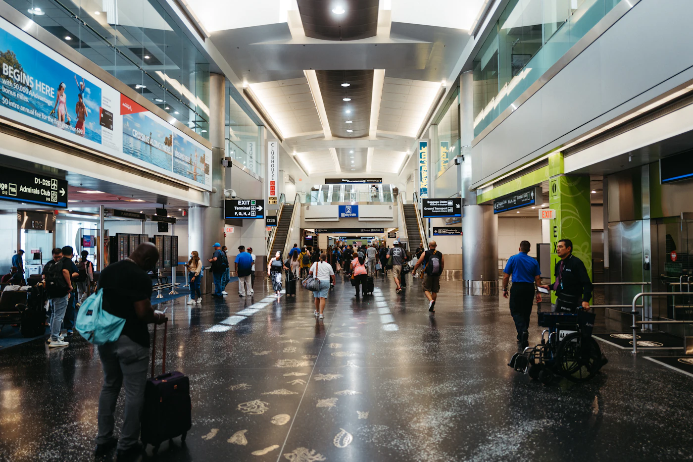 Travelers walking through an airport terminal with carry-on luggage