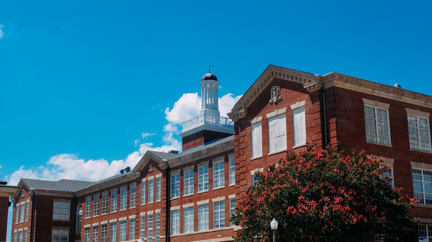 Red-brick campus building and flowering tree in Auburn, Alabama