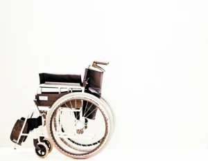 Manual wheelchair with black seat and silver frame against a white background