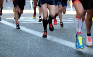 Runners' legs and colorful shoes on a paved road
